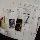 A financial analyst reviewing contract documents and spreadsheets on a laptop