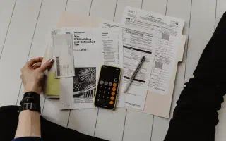 Tax forms and a calculator laid out on a desk