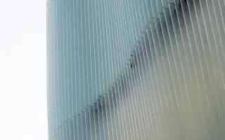 Pale blue vertical fins repeating across a building facade