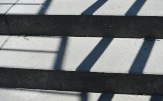 Diagonal shadows falling in bands across concrete steps